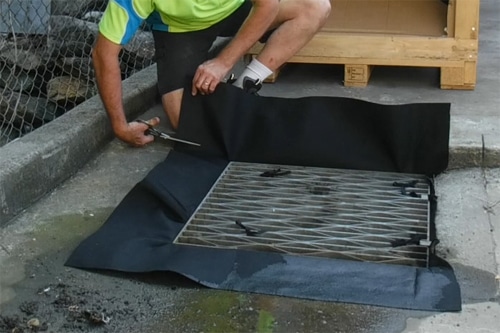 trimming drain warden in situ Chatoyer Drain Warden being trimmed to size during installation into a standard stormwater drain pit