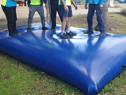 flexible tank water bladder 500x375_0001_bladder tough construction Chatoyer 5 adults standing on a water bladder made of blue PVC